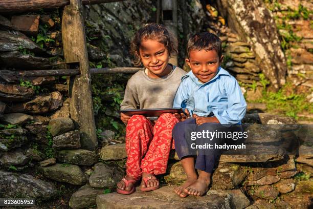nepali children using digital tablet near annapurna range - nepal family stock pictures, royalty-free photos & images