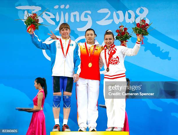 Silver medal winner Alla Vazhenina of Kazakhstan, gold medal winner Cao Lei of China and bronze medal winner Nadezda Evstyukhina of Russia wave to...