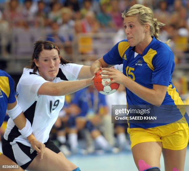 Sweden's Johanna Ahlm vies for the ball with Germany's Stefanie Melbeck during a 2008 Beijing Olympic women's Preliminary Group B handball match on...