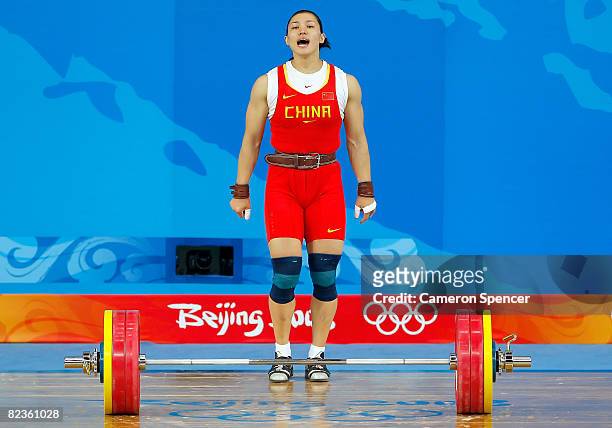 Cao Lei of China reacts after she completes a successful lift in the women's 75kg weightlifting event at the Beijing University of Aeronautics &...