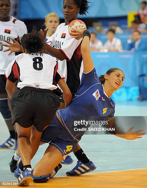 Florina Birsan of Romania shoots at goal after dodging Nair Filipe Pires De Almeida of Angola during their 2008 Beijing Olympic Games women's...