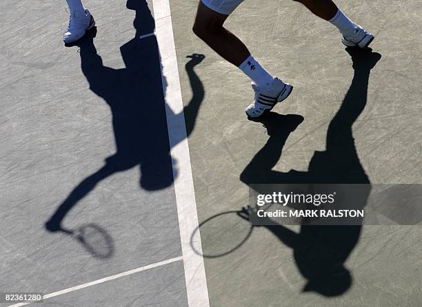 The shadows of Roger Federer of Switzerland and his partner and compatriot Stanislas Wawrinka are seen during their men's doubles quarter-final...