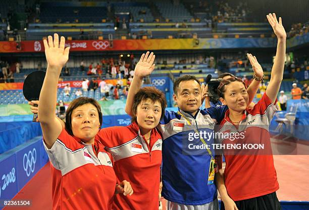 Singapore's table tennis team Wang Yue Gu, Feng Tianwei, head coach Liu Guodong and Li Jia Wei applaud spectators after defeating South Korea's team...