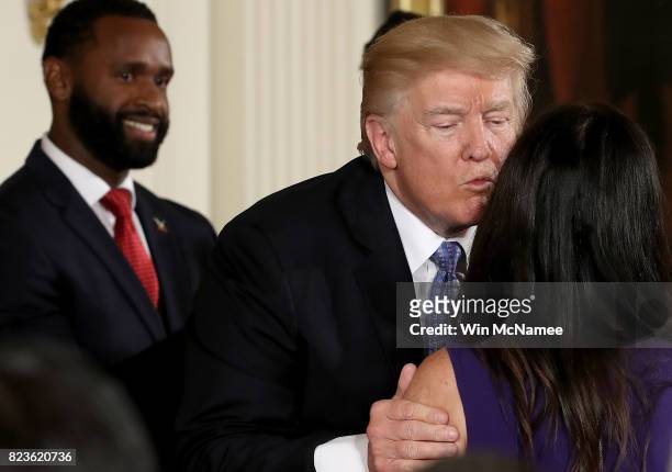 President Donald Trump kisses Jennifer Scalise, wife of Rep. Steve Scalise during an event in the East Room of the White House recognizing the first...