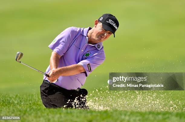 Greg Chalmers of Australia plays his shot out of the bunker on the 10th hole during round one of the RBC Canadian Open at Glen Abbey Golf Club on...