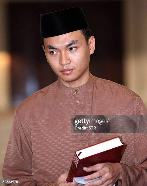 Former aide to Malaysian Opposition Leader Anwar Ibrahim, Mohamad Saiful Bukhari Azlan holds the Quran as he prepares to take an oath at a mosque in...