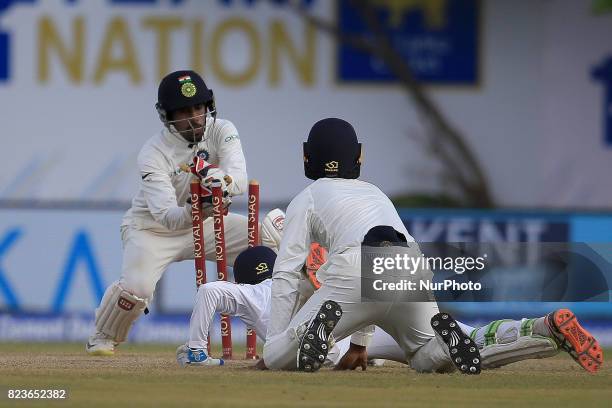 Sri Lankan cricketer Upul Tharanga is run out despite his dive as Indian Wicket keeper Wriddhiman Saha removes the bails during the 2nd Day's play in...