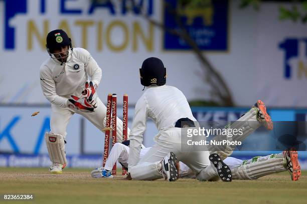 Sri Lankan cricketer Upul Tharanga is run out despite his dive as Indian Wicket keeper Wriddhiman Saha removes the bails during the 2nd Day's play in...