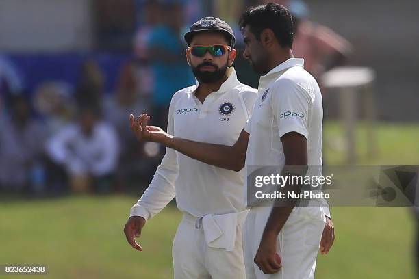 Indian cricket captain Virat Kohli talks to his team mate Ravichandran Ashwin during the 2nd Day's play in the 1st Test match between Sri Lanka and...