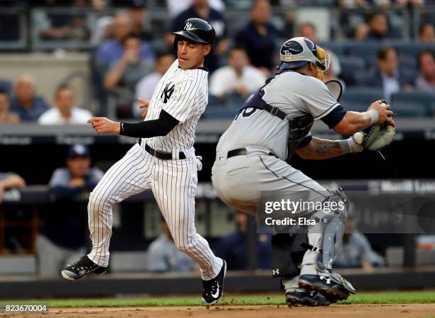Jacoby Ellsbury of the New York Yankees beats the tag and scores past Wilson Ramos of the Tampa Bay Rays in the second inning on July 27, 2017 at...