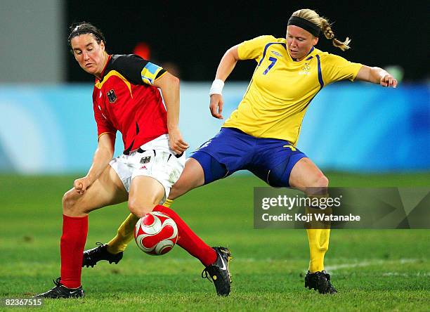 Sara Larsson of Sweden and Birgit Prinz of Germany compete for the ball during the Women's Quarter Final match between Sweden and Germany at Shenyang...