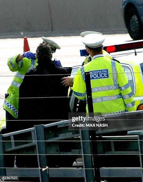 Protester dressed as superhero 'Batman' and thought to be a member of Fathers 4 Justice is arrested after coming down from a gantry above the M25...