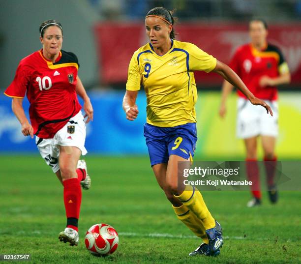 Jessica Landstrom of Sweden and Renate Lingor of Germany compete for the ball during the Women's Quarter Final match between Sweden and Germany at...