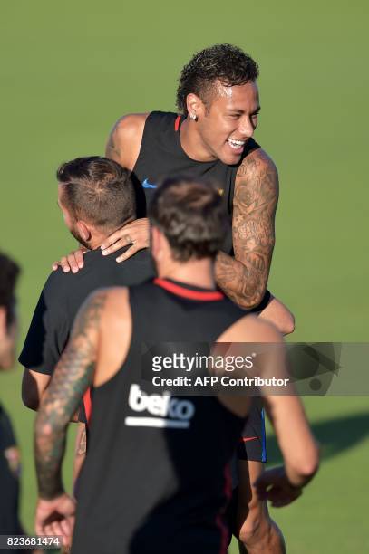 Barcelona player Neymar jokes with teammates during a training session at Barry University in Miami, Florida, on July 27 two days before their...