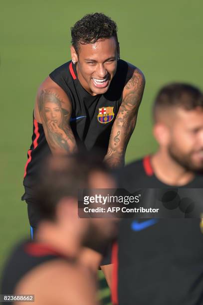 Barcelona player Neymar jokes with teamates during a training session at Barry University in Miami, Florida, on July 27 two days before their...