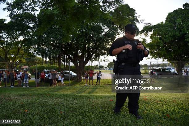 Policeman stands guard during a training session of the Barcelona football team at Barry University in Miami, Florida, on July 27 two days before...