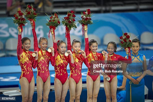 Summer Olympics: Team China Cheng Fei, Yang Yilin, Li Shanshan, He Kexin, Jiang Yuyuan, and Deng Linlin victorious with gold medal on medal stand...