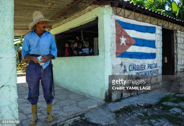 Man stands outside a grocery store in San Luis, Santiago de Cuba province, on June 20, 2017. Each Cuban home receives certain basic foods every month...
