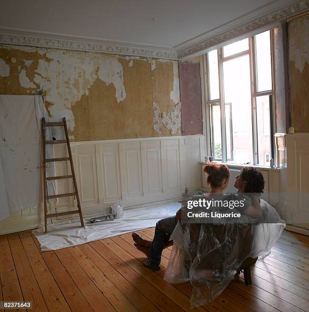 couple looking at partly decorated wall - home improvement stock pictures, royalty-free photos & images