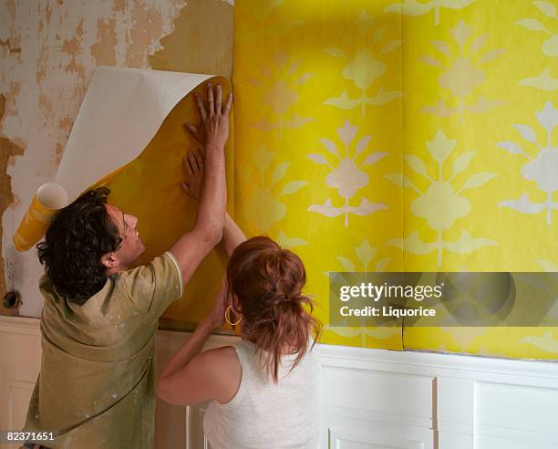 couple hanging wallpaper - interior design - fotografias e filmes do acervo