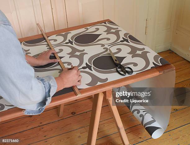 woman measuring wallpaper - papel de parede - fotografias e filmes do acervo