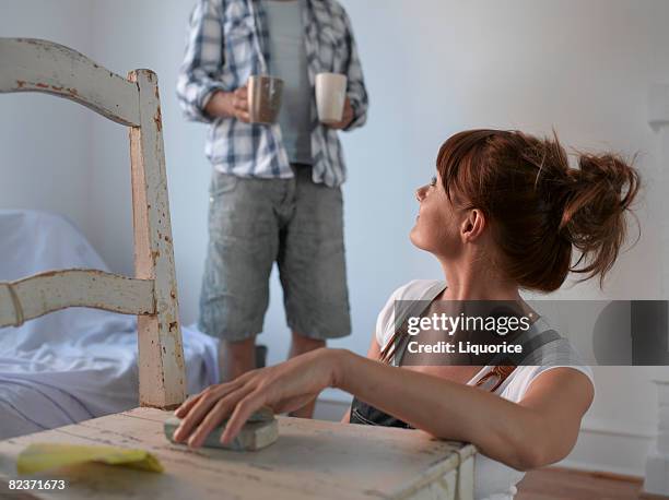 woamn sanding chair man holding cups - sander stock pictures, royalty-free photos & images