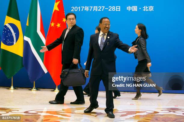 Indian National Security Advisor Ajit Doval reaches out for his brief case before the seventh meeting of BRICS senior representatives on security...