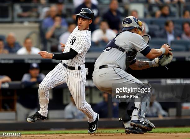Jacoby Ellsbury of the New York Yankees beats the tag and scores past Wilson Ramos of the Tampa Bay Rays in the second inning on July 27, 2017 at...