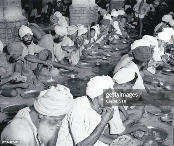 This undated photo taken circa 1947/1948 shows Sikh people eating free food at a relief camp at Khalsa college in Amritsar following unrest in the...