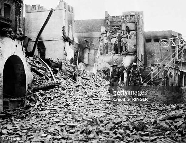 This photo taken in August 1947 shows Indian soldiers walking through the debris of a building in the Chowk Bijli Wala area of Amristar during unrest...