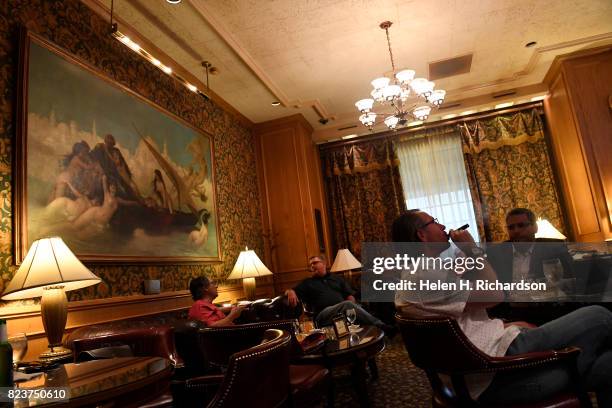 Charles Feldmann, left, and his friend David Nagel enjoy smoking cigars at the Churchill Bar at the Brown Palace on July 25, 2017 in Denver,...
