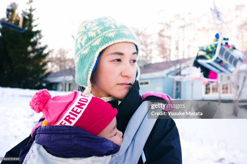 Portrait of mother and daughter embracing in ski area