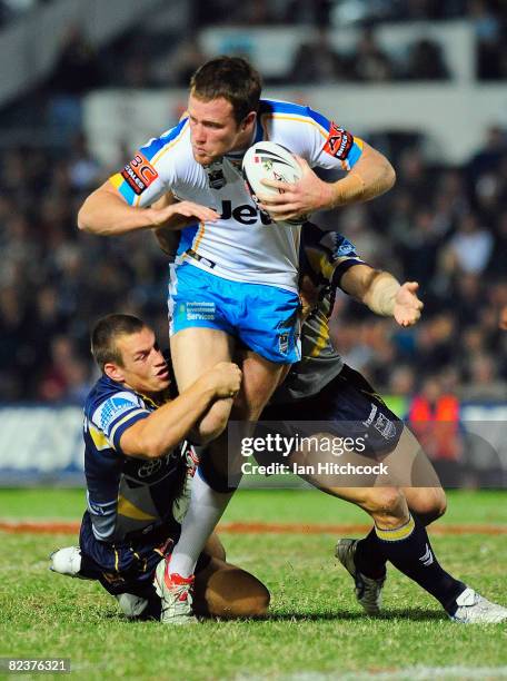 Gavin Cooper of the Titans looks to get through the Cowboy defence during the round 23 NRL match between the North Queensland Cowboys and the Gold...