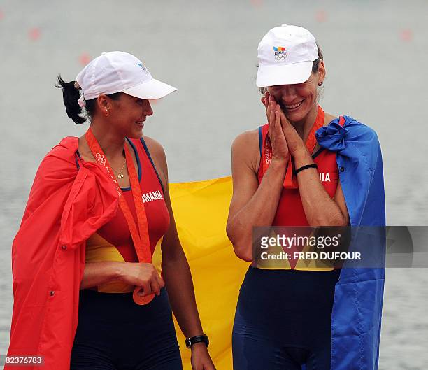 Romania's Georgeta Andrunache and Viorica Susanu celebrate on the podium during the medals ceremony for the women's pair at the Shunyi Rowing and...