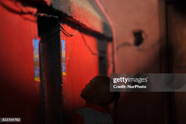 Nepalese kids from Hindu school Bhagwat Sanyaas Aashram Gurukul sticks a picture of a snake god at the main entrance during Nag Panchami festival at...