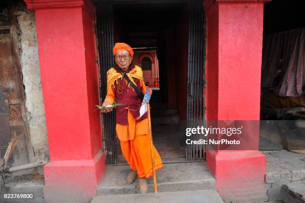 Sadhu carrying poster of snake for rituals offering during Nag Panchami festival at Pashupatinath Temple, Kathmandu, Nepal on Friday, July 28, 2017.