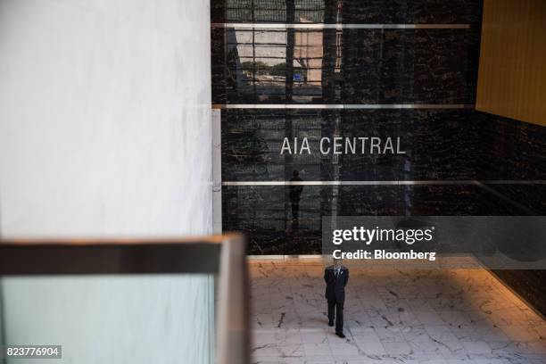 Security officer stands in the lobby of the AIA Central building, which houses the headquarters of AIA Group Ltd., in Hong Kong, China, on Friday,...