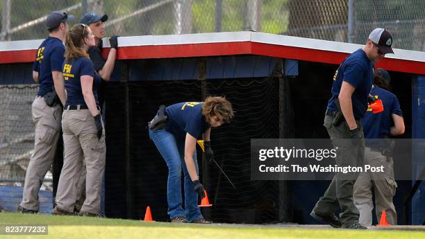 Evidence technicians mark spots at the 3rd base dugout during the aftermath of the shooting at a Congressional baseball practice in Alexandria VA,...