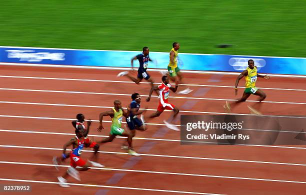 Usain Bolt of Jamaica celebrates as he approaches the line on his way to winning the Men's 100m Final at the National Stadium on Day 8 of the Beijing...