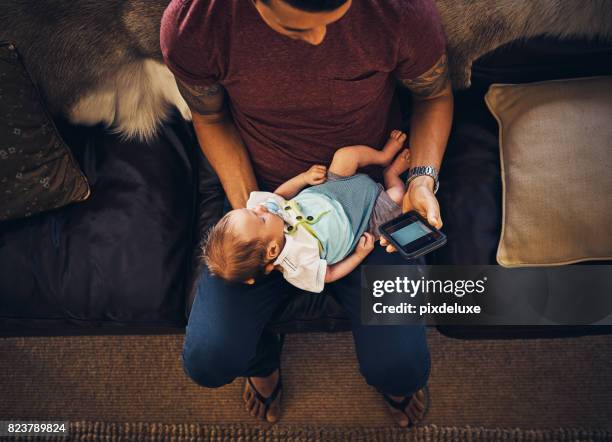 distracted from daddy duties - baby smartphone stock pictures, royalty-free photos & images