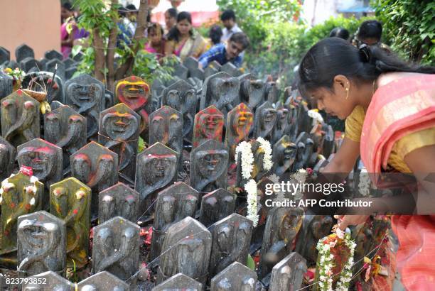 An Indian Hindu devotees offers prayers to statues of snakes to mark the Nag Panchami festival at a temple in Secunderabad, the twin city of...