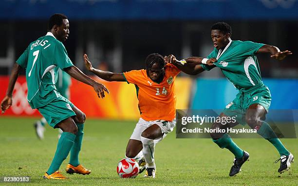 Gervinho of Ivory Coast competes for the ball with Dele Adeleye and Chinedu Ogbuke Obasi of Nigeria during the Men's Quarter Final match between...