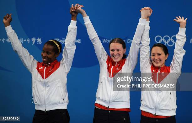 S Erinn Smart, Emily Cross and Hanna Thompson celebrate with their silver medals on the podium at the end of the women's team foil event on August...