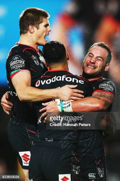 Bodene Thompson celebrates after scoring a try with Blake Ayshford and Roger Tuivasa-Sheck of the Warriors during the round 21 NRL match between the...