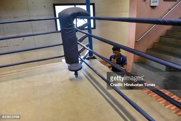 National Boxing Medallist and four-time state gold medallist Akshay Mare prays before entering in boxing ring for training session at Lahuji Vastad...