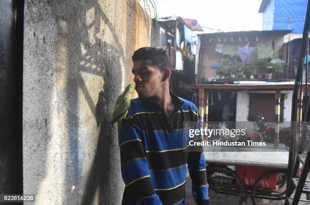 National Boxing Medallist and four-time state gold medallist Akshay Mare shares light moment with a pet parrot outside of his house in slum area at...