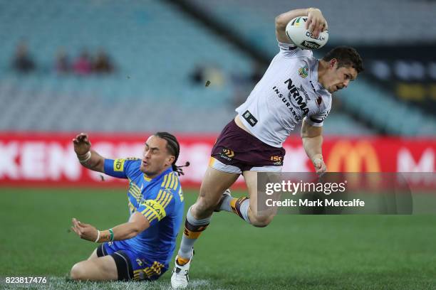 James Roberts of the Broncos evades the tackle of Brad Takairangi of the Eels during the round 21 NRL match between the Parramatta Eels and the...