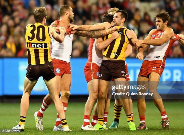 Lance Franklin of the Swans and Luke Hodge of the Hawks push and shove during the round 19 AFL match between the Hawthorn Hawks and the Sydney Swans...