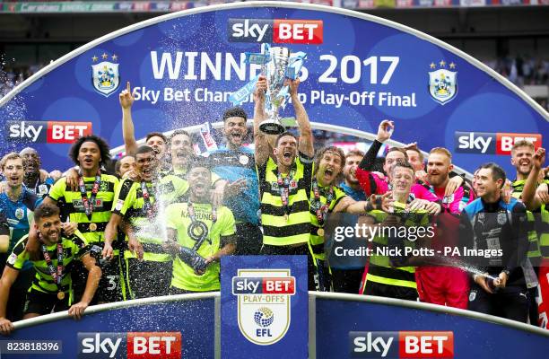 Huddersfield Town' captain Mark Hudson lifts the trophy with his celebrating teammates after winning the Sky Bet Championship play-off final at...