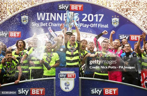 Huddersfield Town' captain Mark Hudson lifts the trophy with his celebrating teammates after winning the Sky Bet Championship play-off final at...